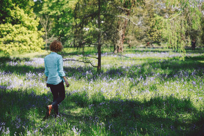 Woman walking amidst plants at forest