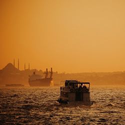 Boat sailing in sea at sunset