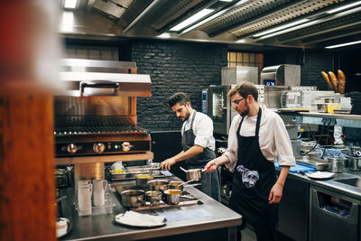 Professional chefs working in team cooking in kitchen