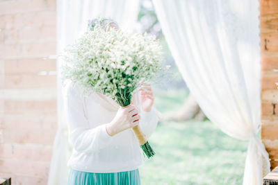 Close-up of woman holding white flower