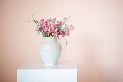 Close-up of flower vase against white wall