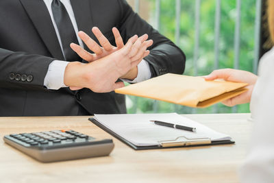 Midsection of man and woman holding table