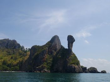 Rock formations by sea against sky