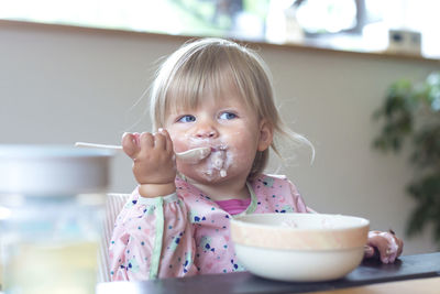 Cute girl eating ice cream at home