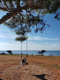 View of swing on beach against sky