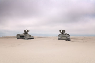 2 army tanks on the beach with bullet holes