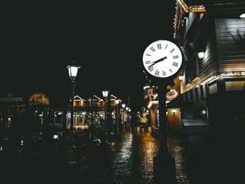 Illuminated clock tower against sky at night