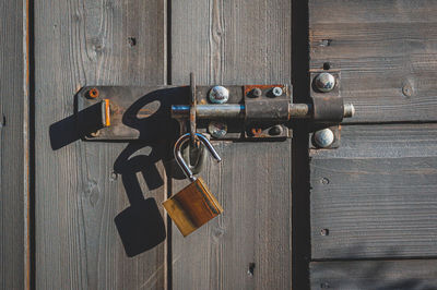 Close-up of padlocks on wooden door