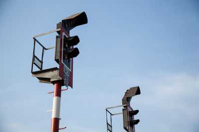 Low angle view of railway signals against sky