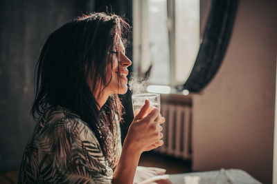 Side view of young woman using mobile phone