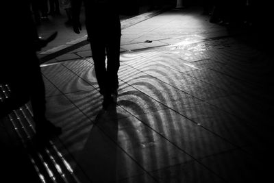 Low section of people standing on tiled floor