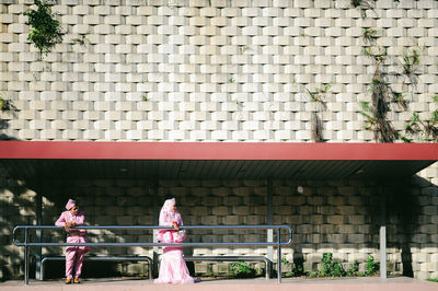 Rear view of woman standing against building