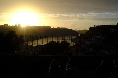 Silhouette city against sky during sunset