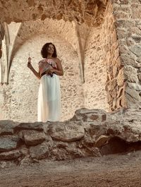 Full length of woman standing against wall