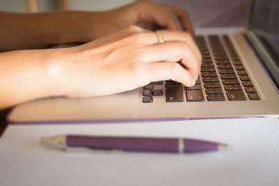 Cropped image of woman using laptop
