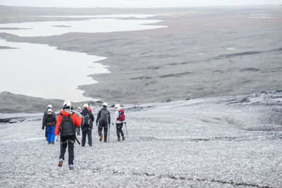 Rear view of people walking on land