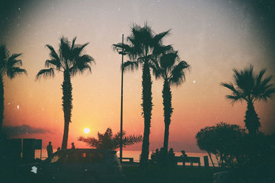 Silhouette palm trees against sky during sunset