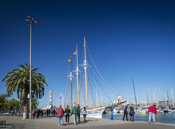 People on street against clear blue sky