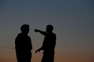 Silhouette man standing against sky at sunset