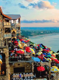 Multi colored umbrellas by sea against sky