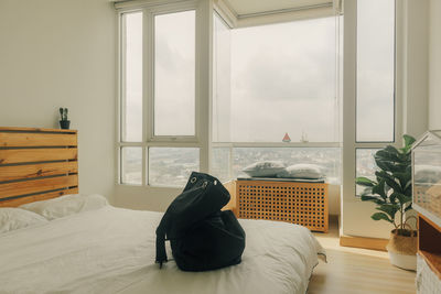 Man relaxing on bed by window at home