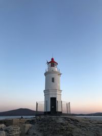 Low angle view of lighthouse amidst buildings against sky