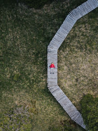 Aerial view of woman relaxing on footpath over field