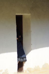 Low section of woman standing by built structure