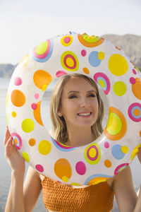 Woman holding inflatable ring at beach