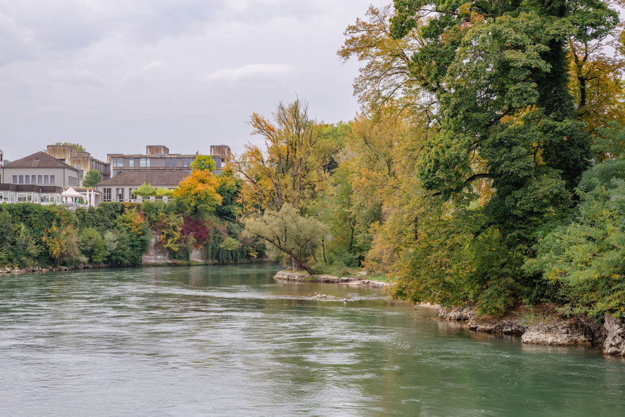 river, water, tree, architecture, plant, built structure, nature, building exterior, sky, building, body of water, travel destinations, beauty in nature, autumn, travel, cloud, environment, no people, house, city, tourism, scenics - nature, outdoors, waterway, waterfront, landscape, flower, tranquility, day, residential district, land, tranquil scene, vacation, trip, leaf, pond, holiday, idyllic