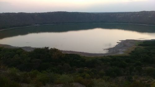 Scenic view of lake by mountains against sky