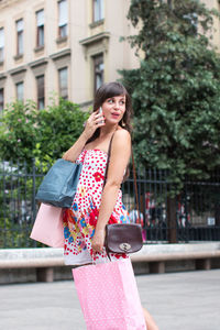 Portrait of smiling young woman standing on street