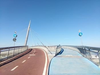 Road sign against clear blue sky