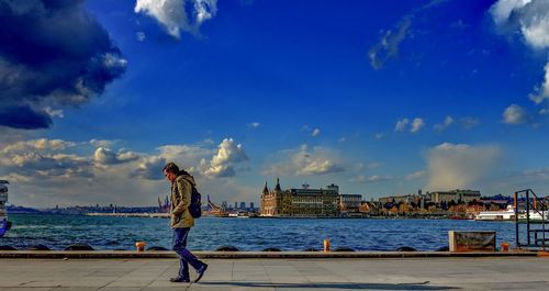 Man standing in sea against sky