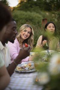 Portrait of smiling friends enjoying picnic