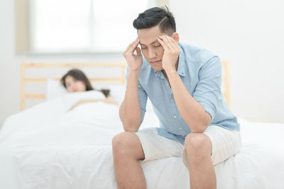 Young couple sitting on bed