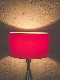 Close-up of illuminated lamp against wall