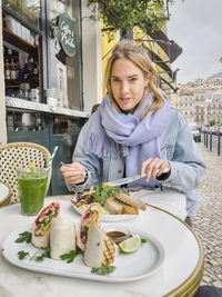 Portrait of smiling young woman having food at home