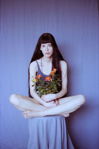 Portrait of woman standing against wall