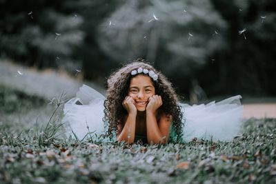 Portrait of a smiling young woman lying on field