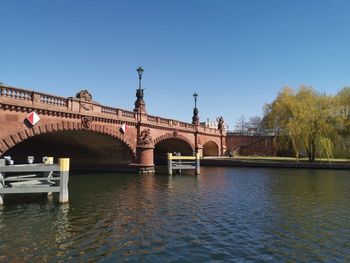 Bridge over river against clear blue sky