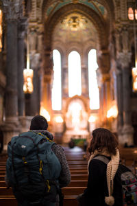 Friends wearing backpacks while standing in church