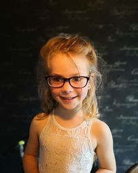 Smiling girl standing against wall