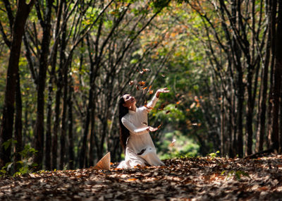 Full length of woman standing in forest