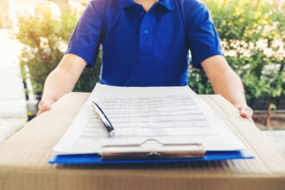 Midsection of man working on table