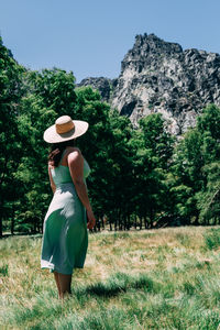 Rear view of woman wearing hat against trees