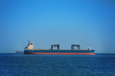 Ship in sea against clear blue sky