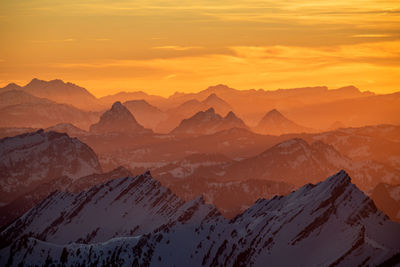 Scenic view of snowcapped mountains against sky during sunset