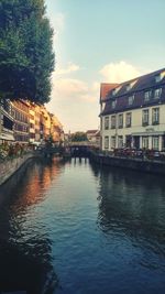 Canal amidst buildings against sky