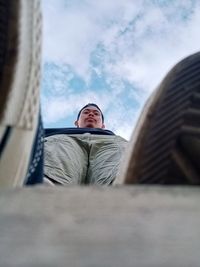 Low angle portrait of man against sky